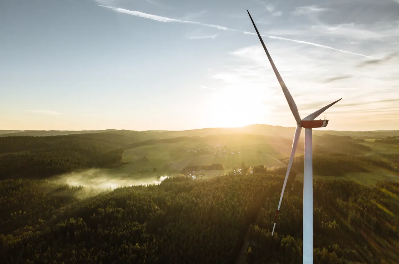 Drohnen-Luftaufnahme — Windrad im Sauerland bei Sonnenaufgang über Wäldern und Nebel