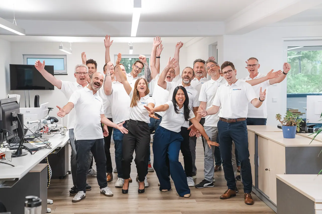 Eventfotografie — jubelndes Manntech Team bei der Alimak Büroeröffnung