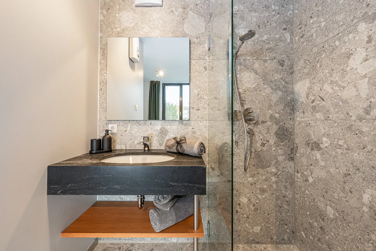 Architekturfotografie — Badezimmer mit Terrazzo und Steinwaschtisch