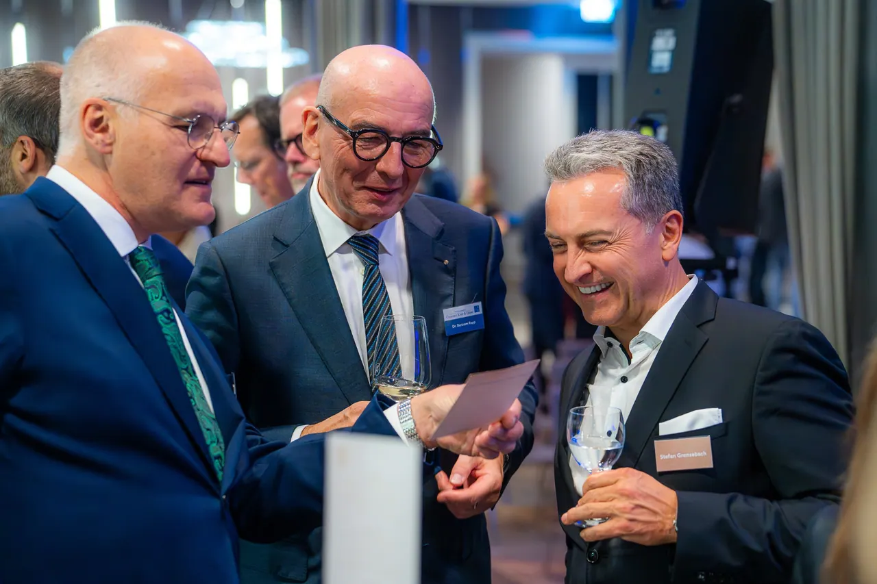 Eventfotografie — Drei Herren im Gespräch mit Weinglas
