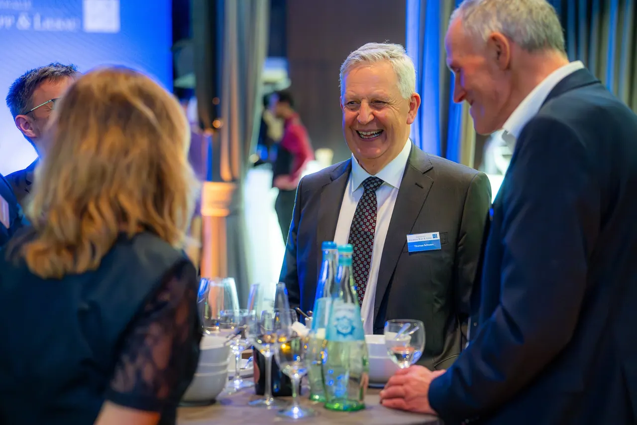 Eventfotografie — Lachende Gästegruppe am Stehtisch