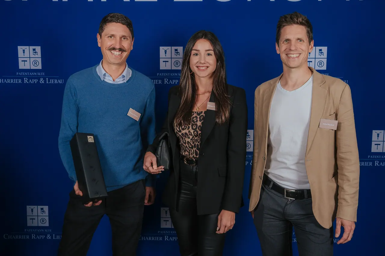 Eventfotografie — Drei Gäste am Photocall mit Kanzlei-Branding
