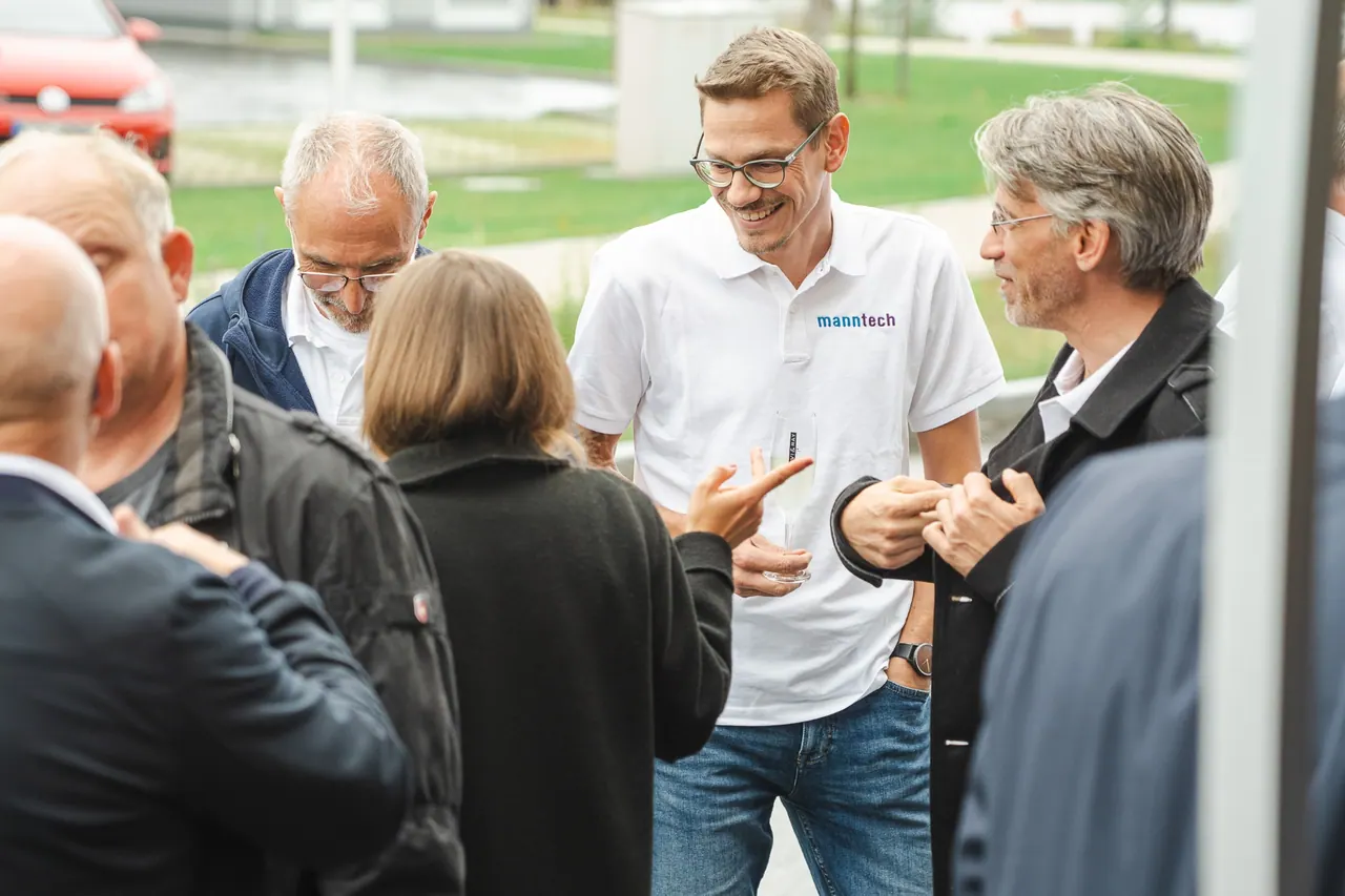 Manntech/Alimak Büroeröffnung — Mitarbeiter im Gespräch mit Gästen