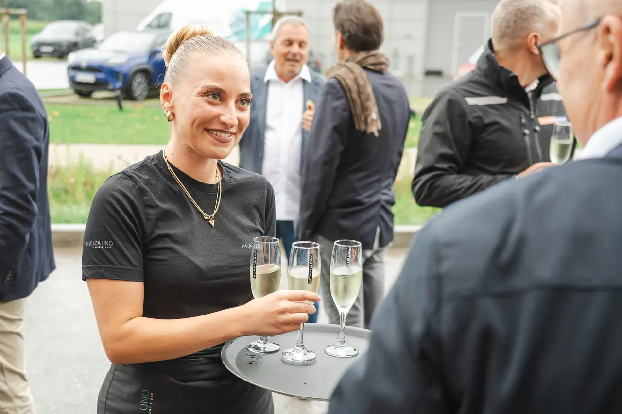 Manntech/Alimak Büroeröffnung — Servicekraft mit Sekt-Tablett