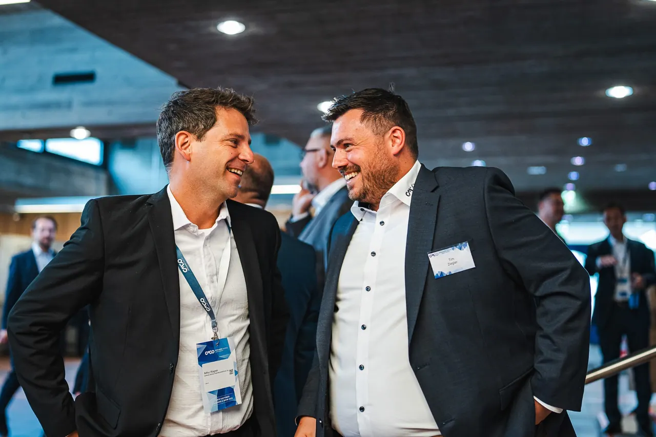 CMCO Customer Exchange & Show 2025 — Lachende Gäste mit CMCO-Lanyards im Foyer