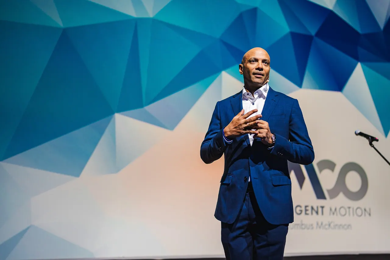 CMCO Customer Exchange & Show 2025 — Keynote-Speaker im blauen Anzug auf der Bühne