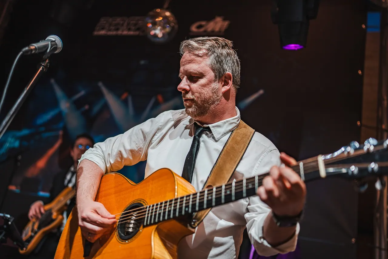 CMCO Customer Exchange & Show 2025 — Live-Musiker mit Akustikgitarre auf der Bühne