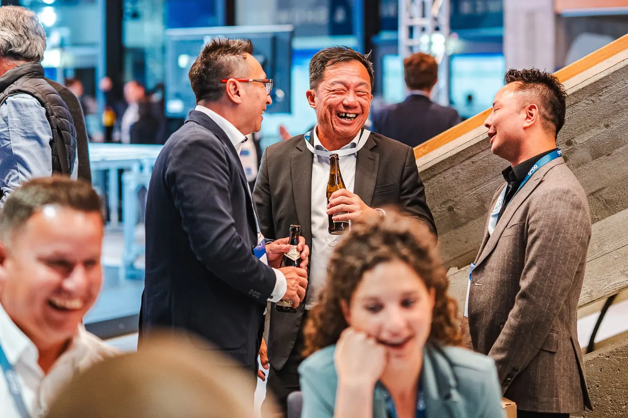 CMCO Customer Exchange & Show 2025 — Lachende Gäste mit Bier in der Networking-Pause
