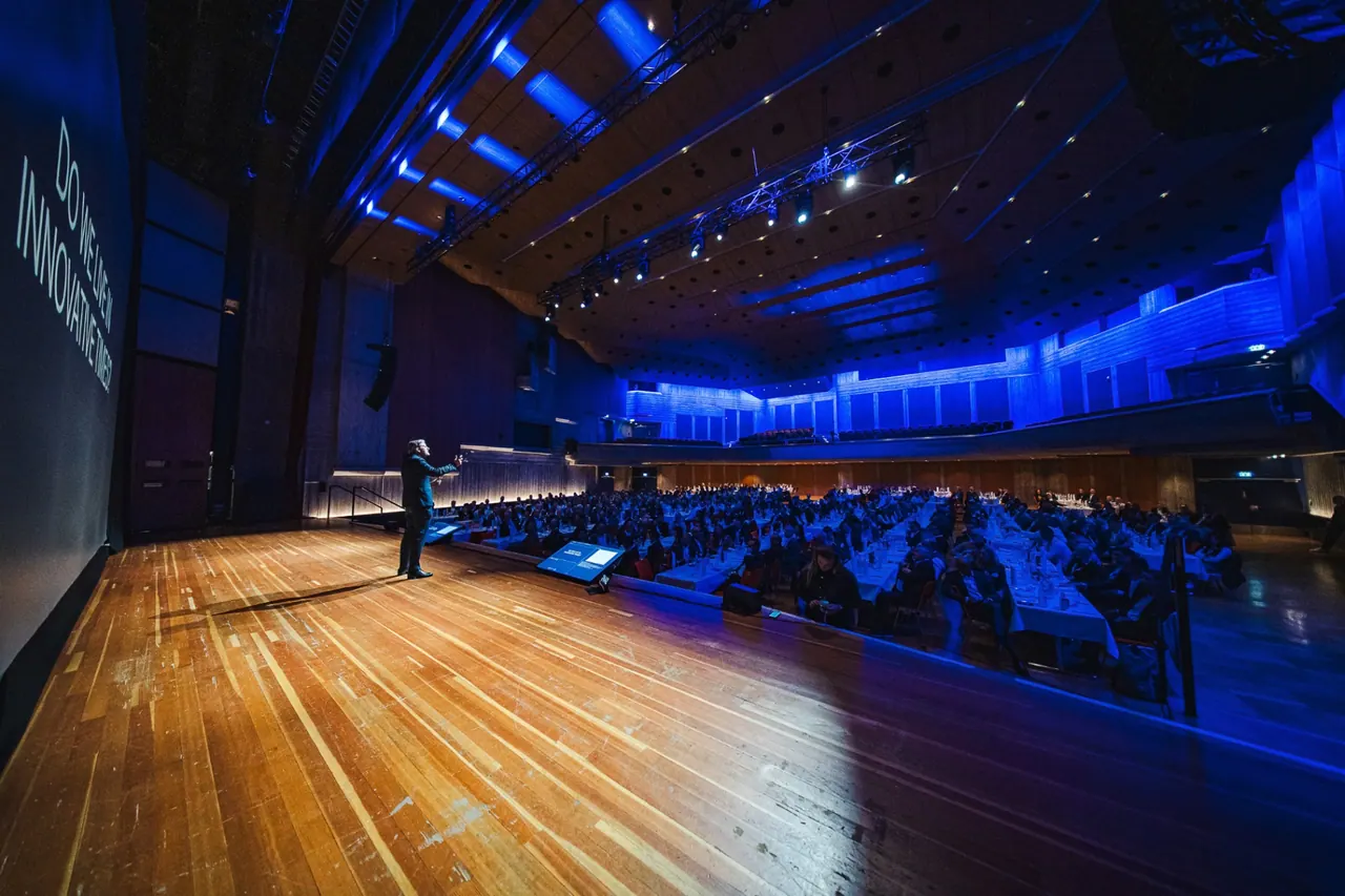 CMCO Customer Exchange & Show 2025 — Keynote-Speaker im blau ausgeleuchteten Saal