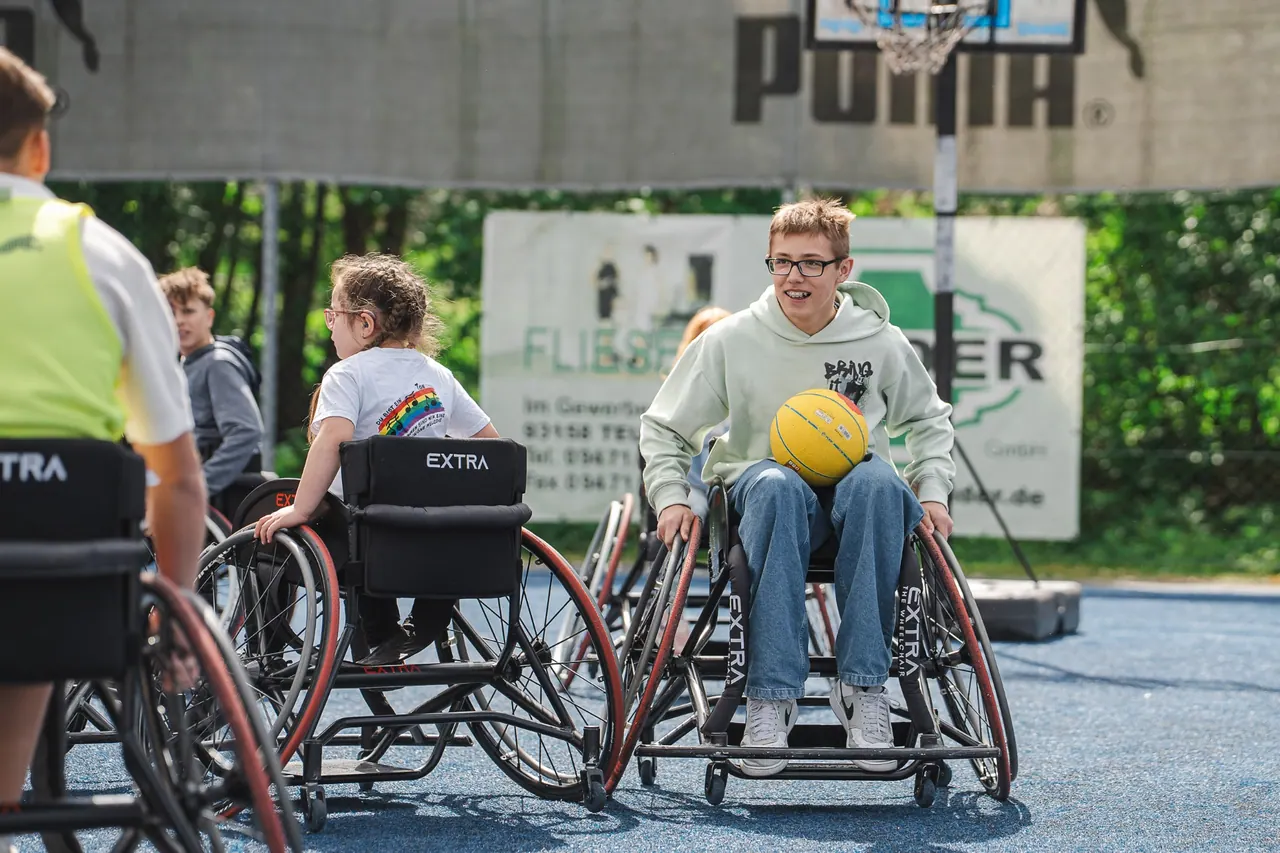 R+V Herzmomente 2025 — Jugendlicher im Sportrollstuhl mit Basketball auf dem Court