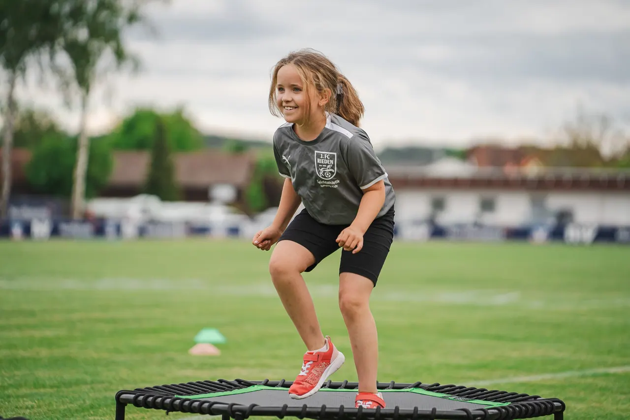 R+V Herzmomente 2025 — Mädchen springt lachend auf einem Mini-Trampolin