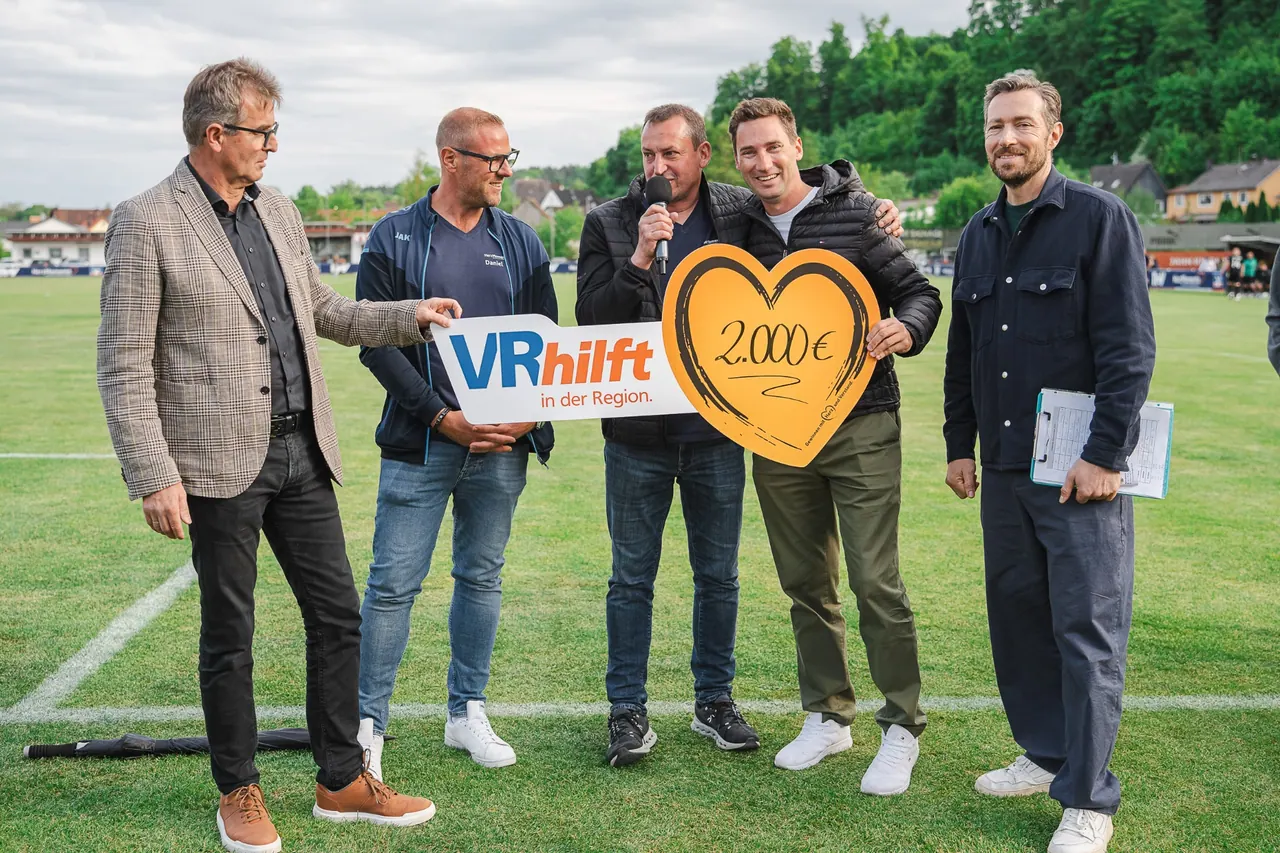 R+V Herzmomente 2025 — Spendenübergabe VR hilft mit 2.000-Euro-Herz-Scheck auf dem Spielfeld