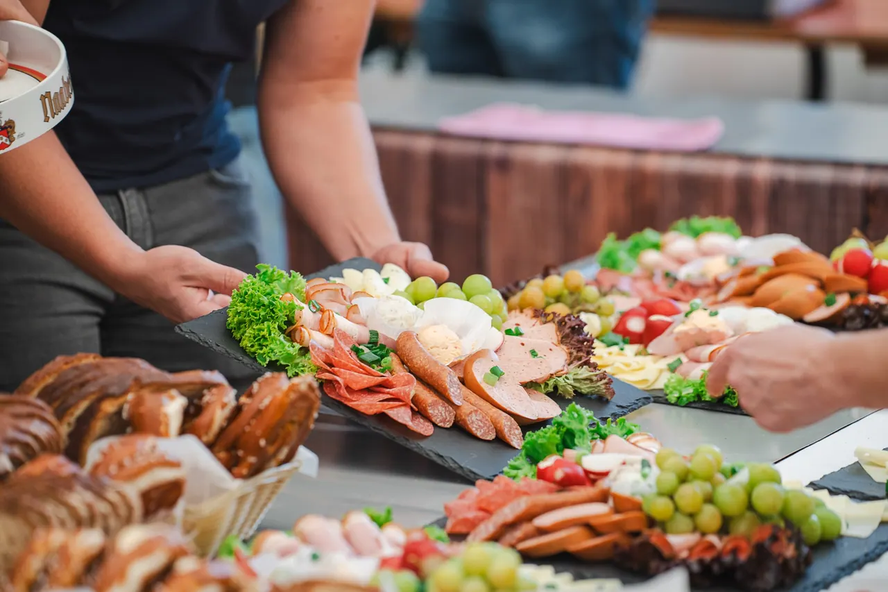 R+V Herzmomente 2025 — Aufgebackene Brotzeitplatten mit Wurst, Käse und Trauben am Buffet