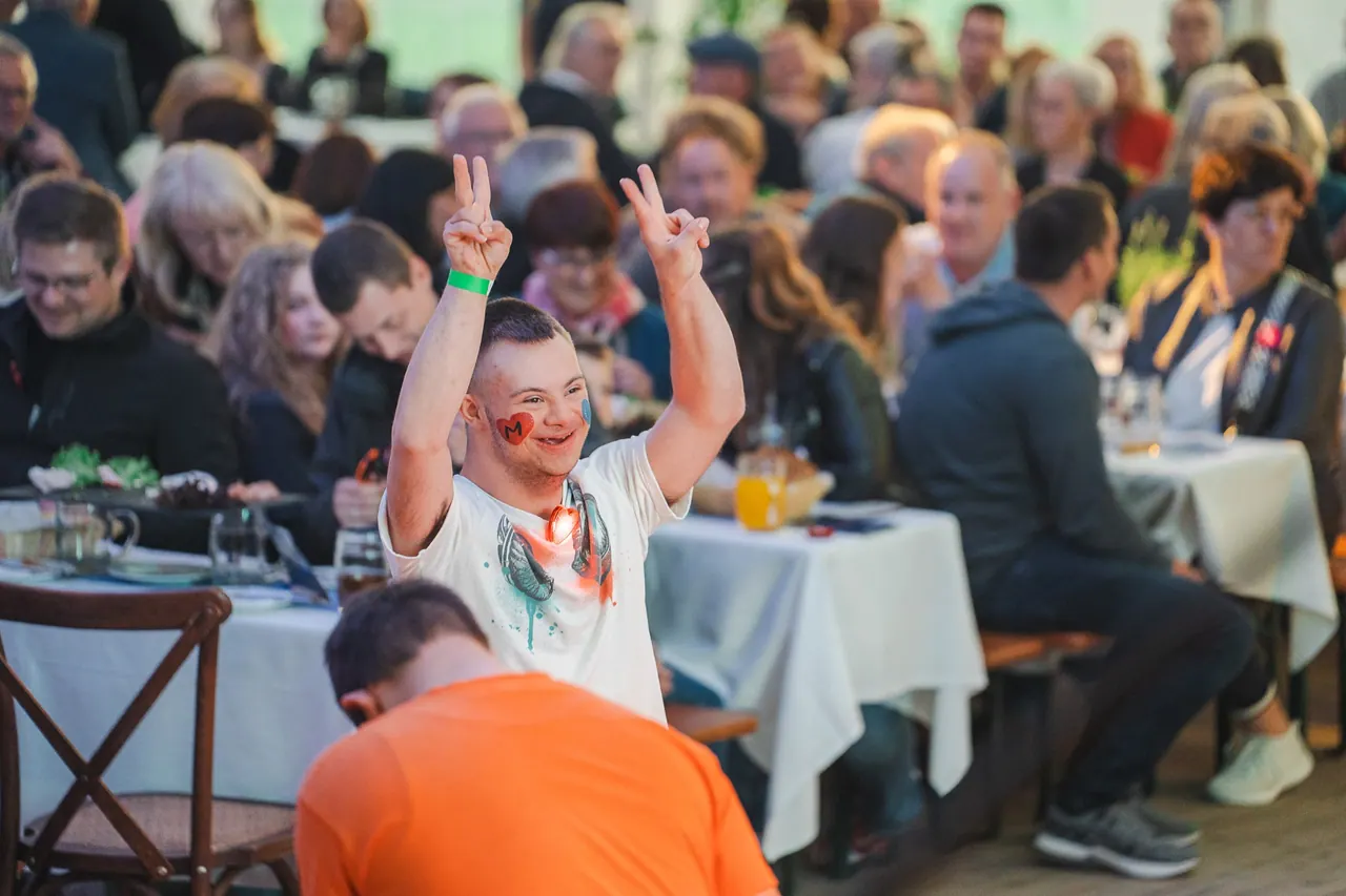R+V Herzmomente 2025 — Begeisterter Gast mit Herz-Bodypaint jubelt mit erhobenen Armen im Festzelt