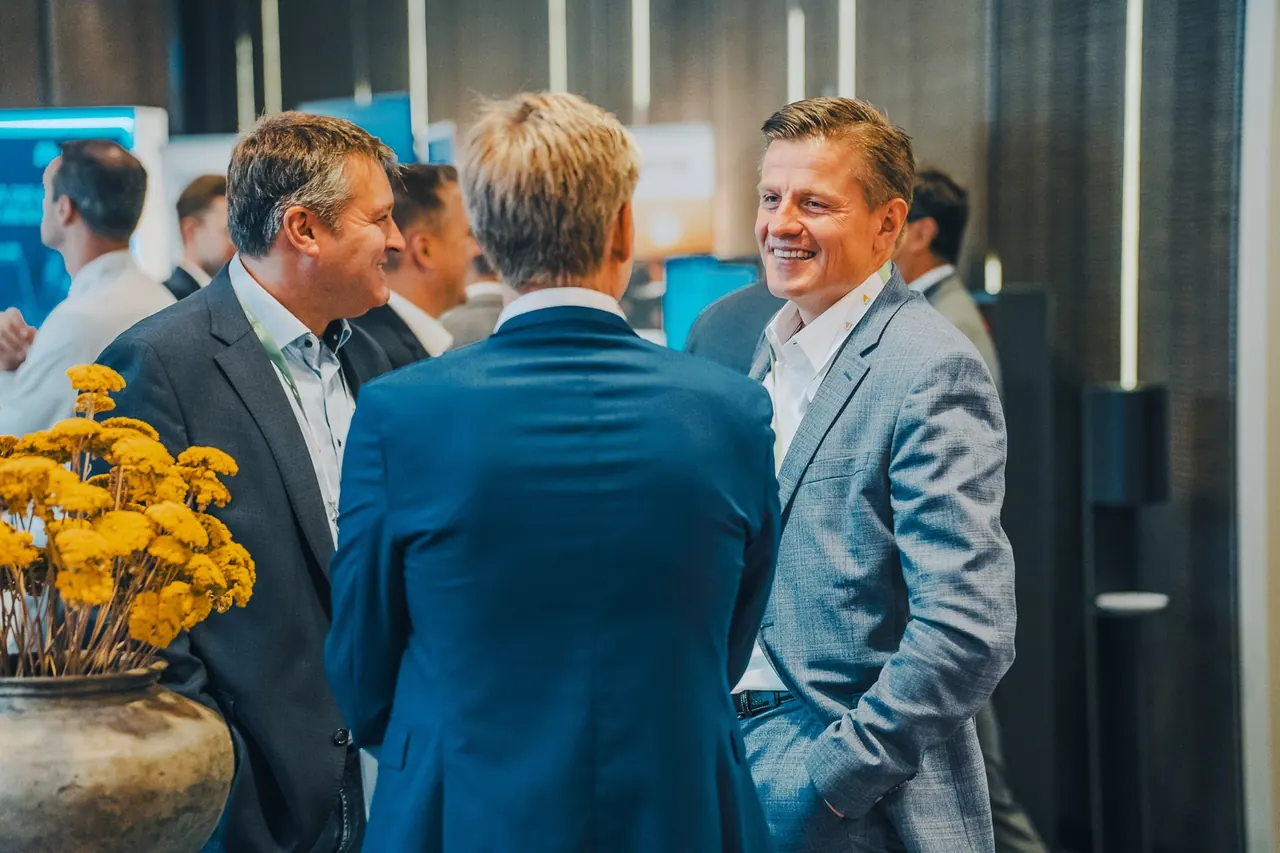 Agritech - Berlin Institute — Drei Geschäftsmänner im angeregten Gespräch zwischen Messe-Ständen