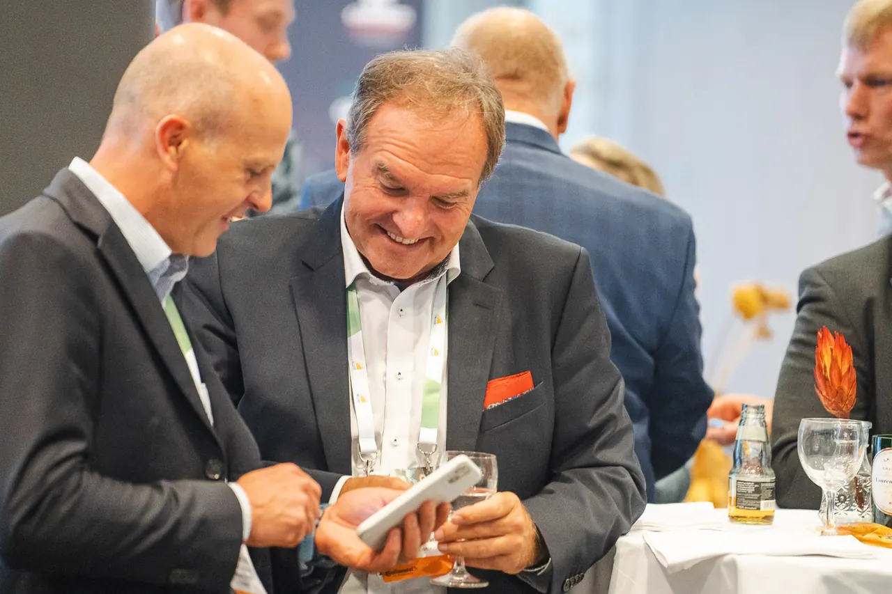 Agritech - Berlin Institute — Zwei Gäste schauen gemeinsam lachend auf ein Smartphone